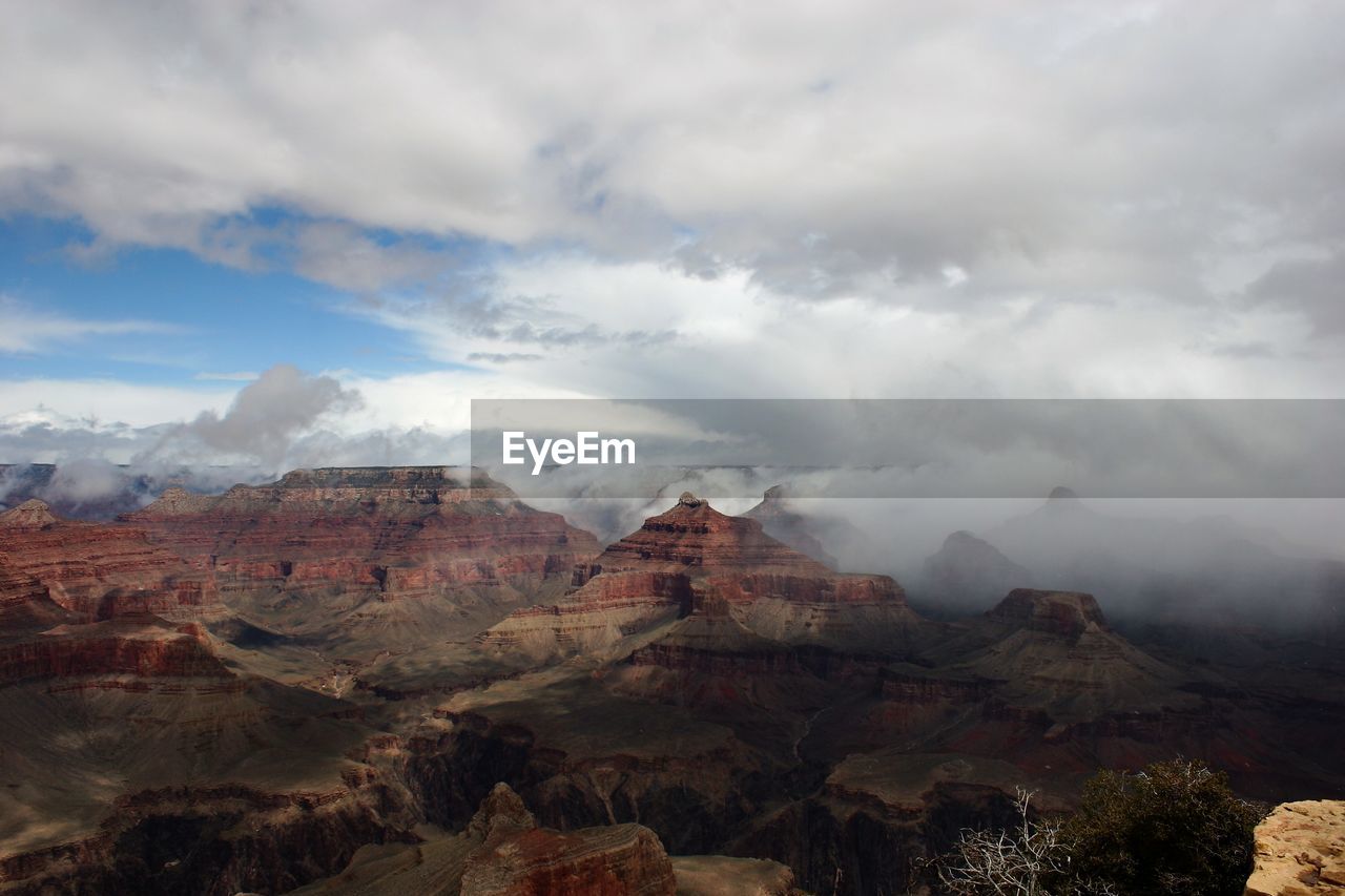 Scenic view of mountains against cloudy sky