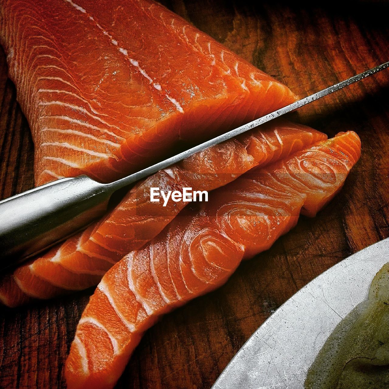 Close-up of knife on salmon at table