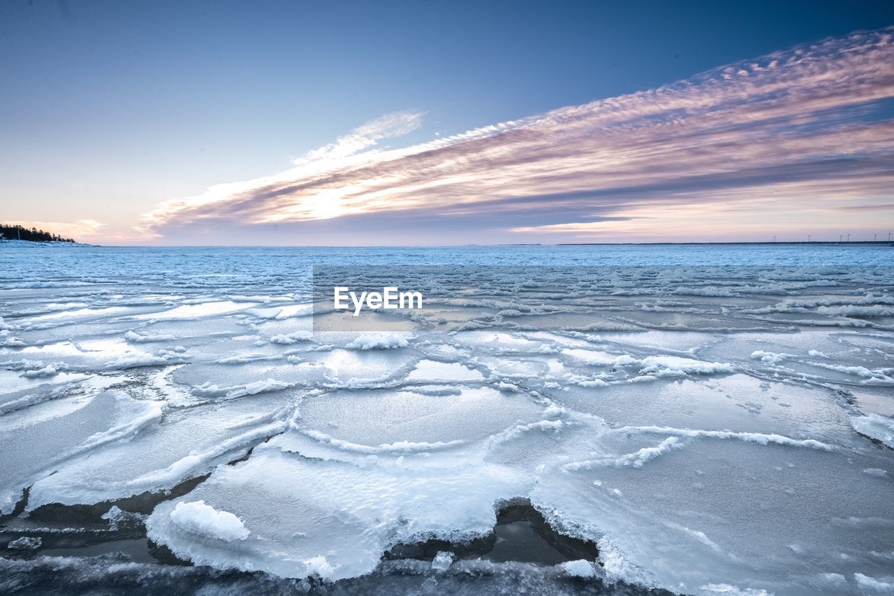 Scenic view of frozen sea against sky during sunset