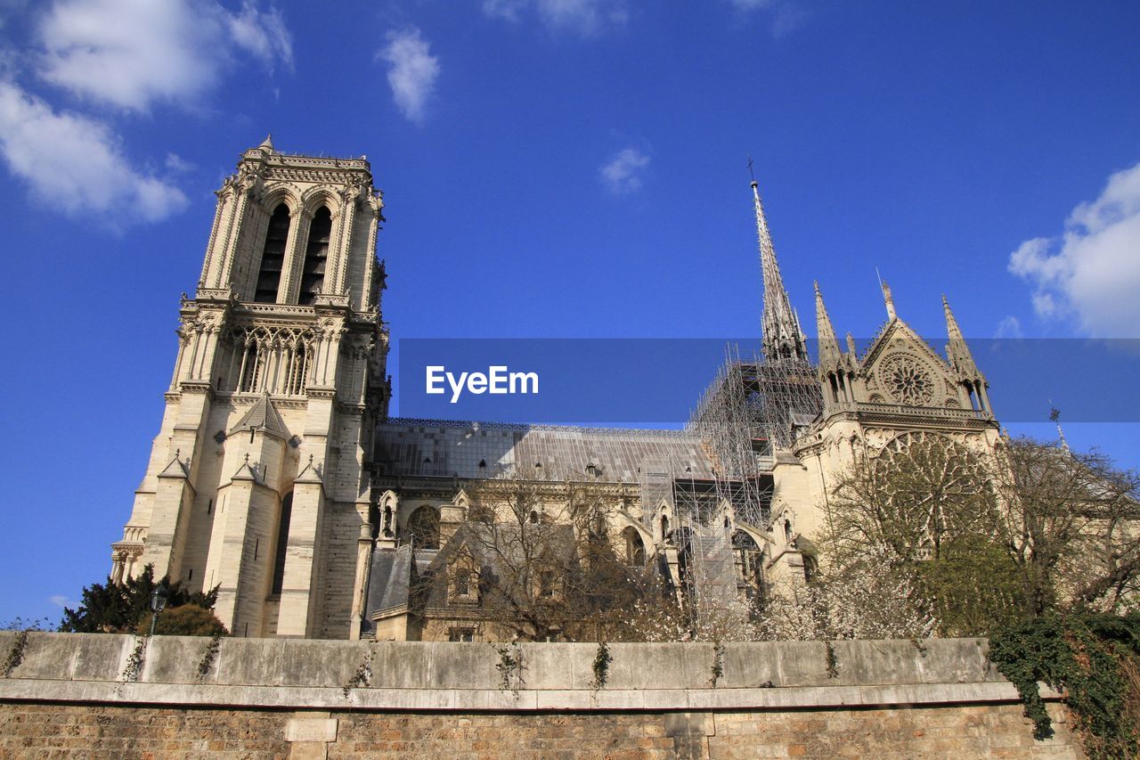 Low angle view of historic notre dame against sky