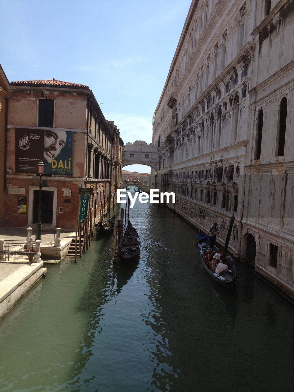 BOATS IN CANAL AMIDST BUILDINGS IN CITY