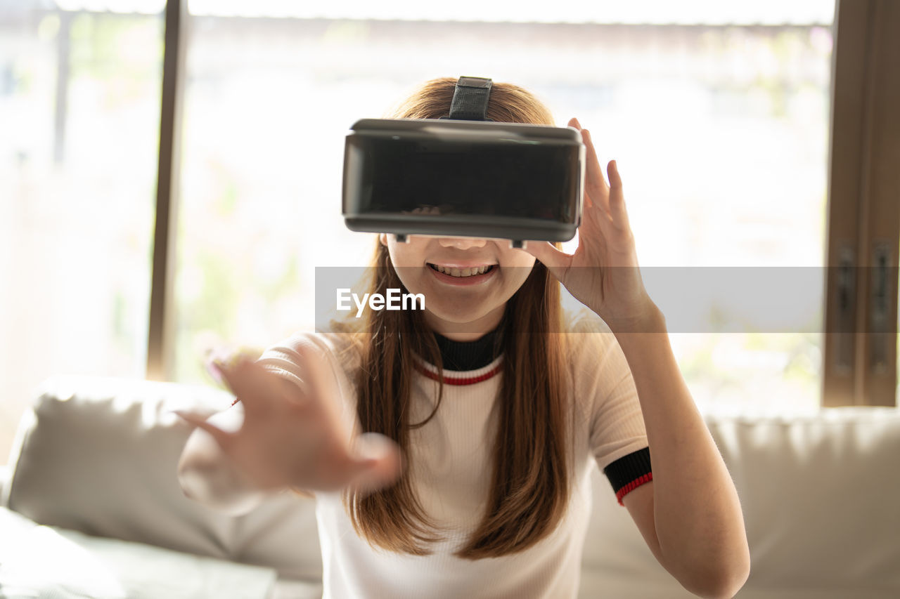 Smiling girl gesturing wearing virtual reality headset