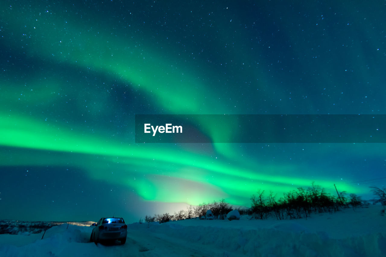 SCENIC VIEW OF SNOW COVERED FIELD AGAINST SKY AT NIGHT