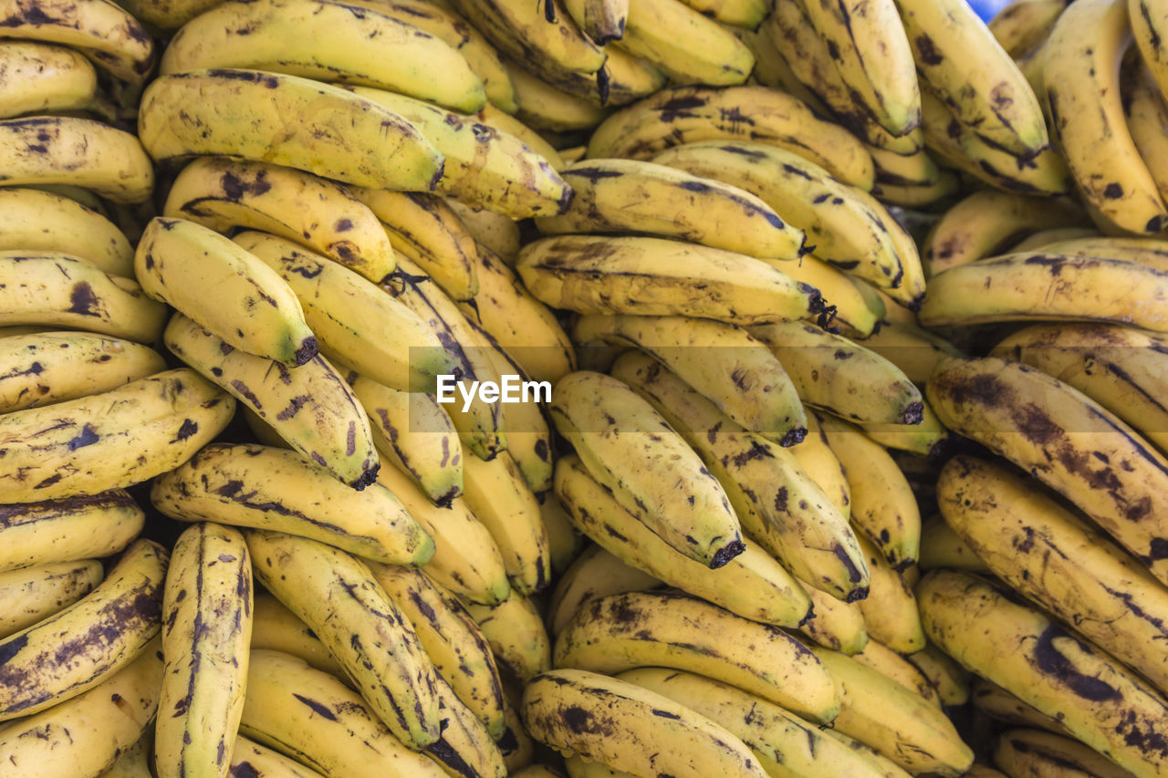 Background of a hand of bananas stack on stall in street market, delhi, india