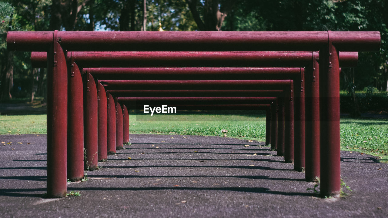 plant, park, park - man made space, tree, empty, no people, day, nature, the way forward, outdoors, absence, red, footpath, architecture, furniture, bench, seat, wood, sunlight, grass, land
