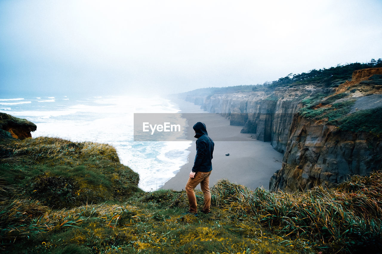 Side view of man standing on cliff