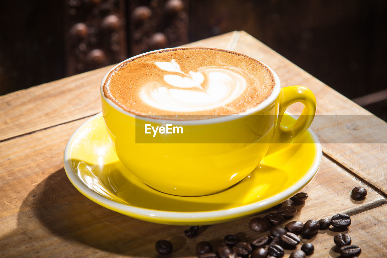 High angle view of coffee cup on wooden table