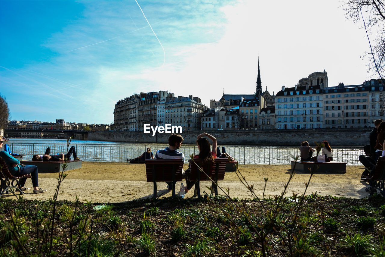 People on benches by river