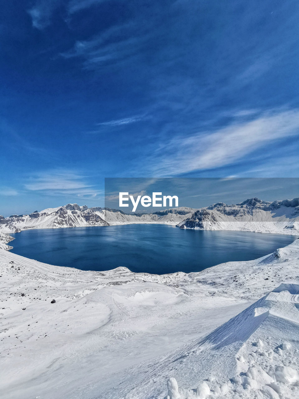 Scenic view of snowcapped mountains against blue sky