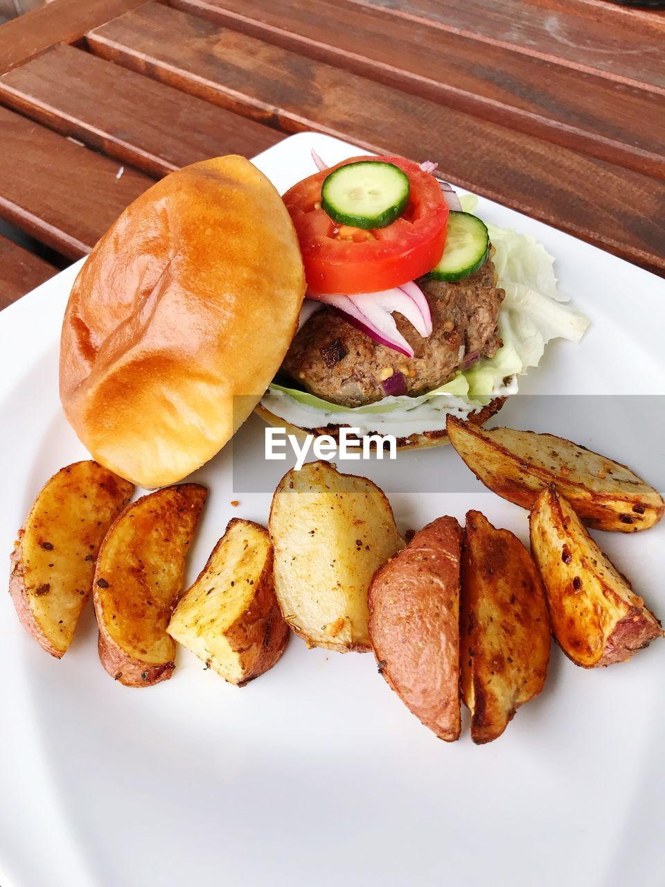 Homemade burger on plate with baked potato fries