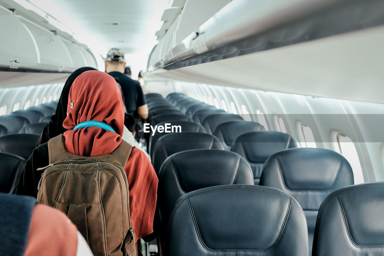 Rear view of people standing in airplane
