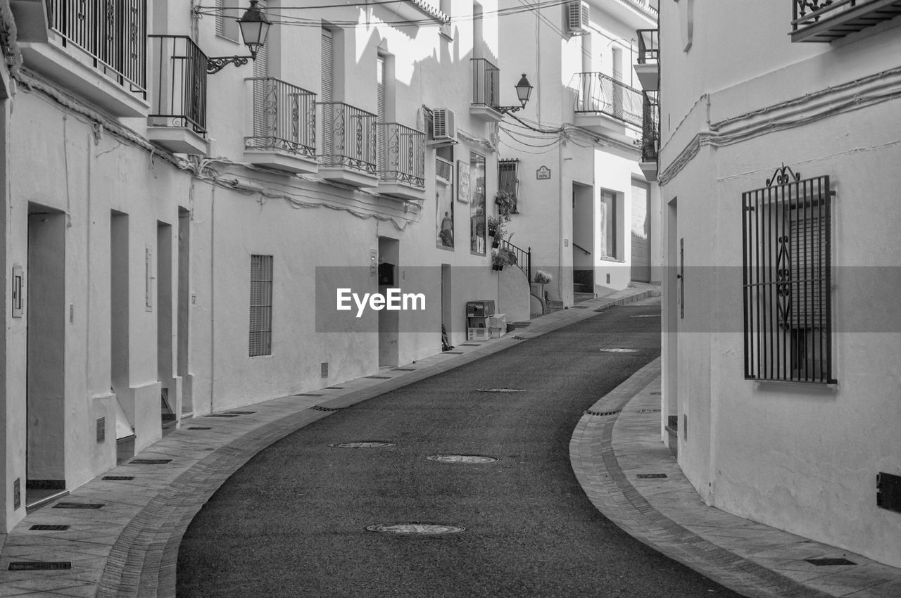 Empty narrow alley along buildings