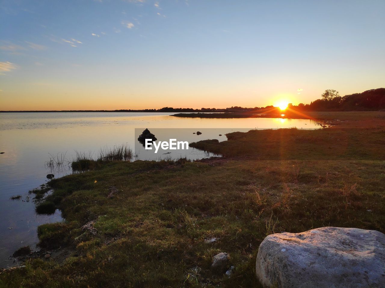 Scenic view of lake against sky during sunset