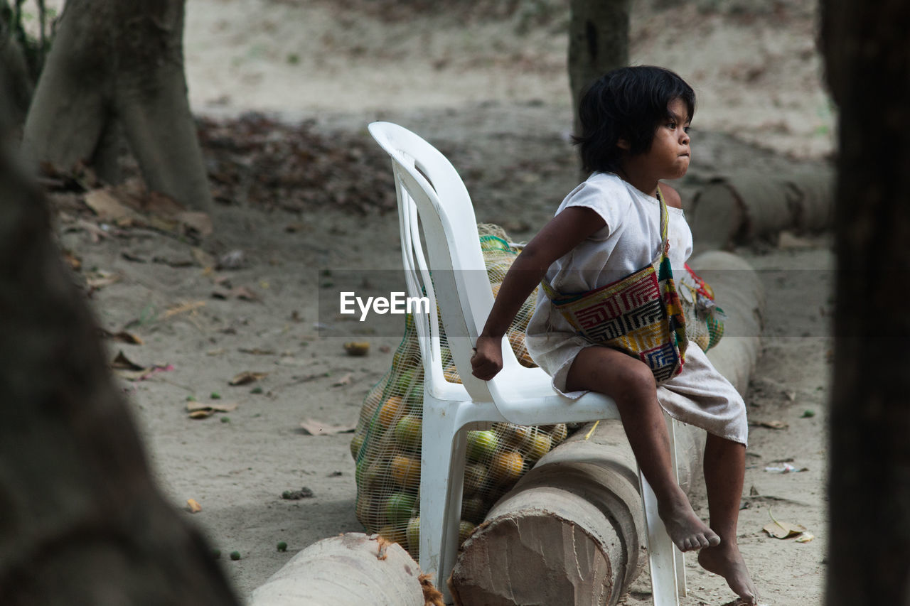 FULL LENGTH OF BOY SITTING ON STREET