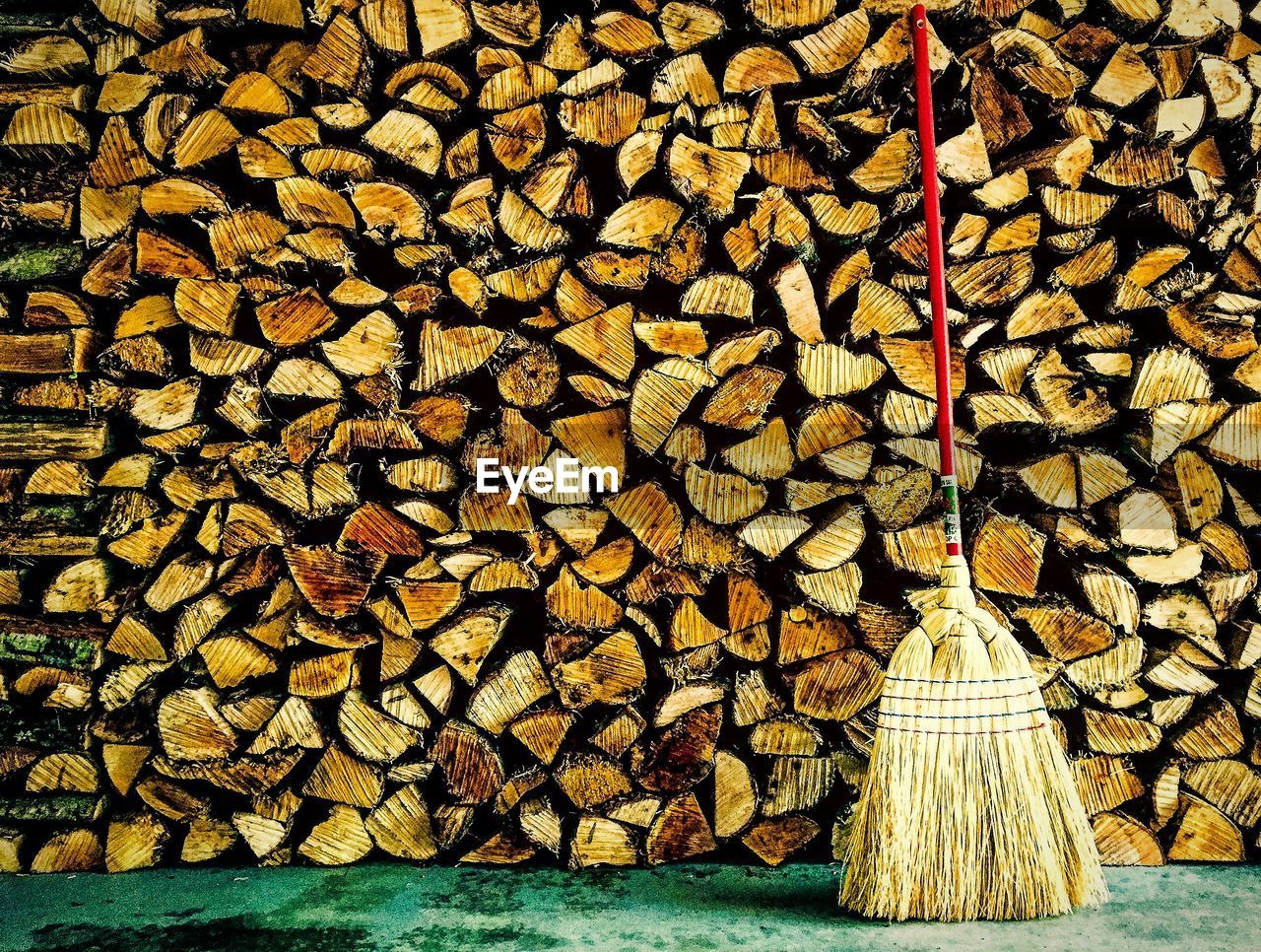 Broom against stacked logs