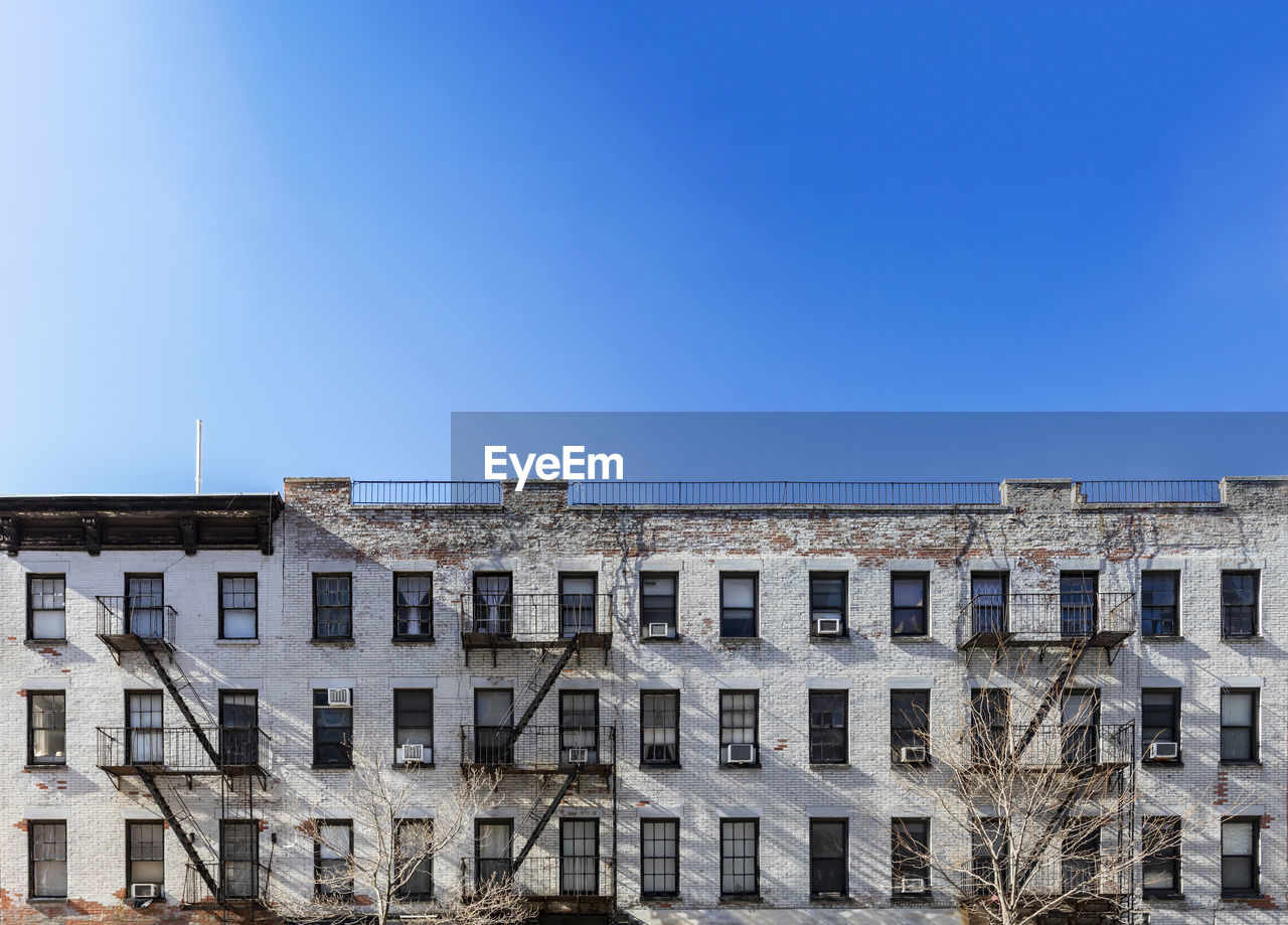 Low angle view of buildings against clear blue sky