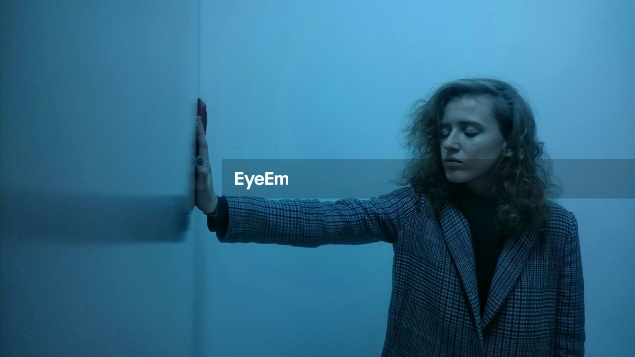 Woman with eyes closed standing in room