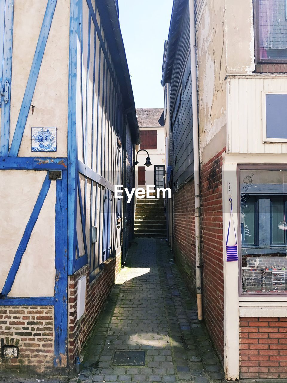 NARROW ALLEY AMIDST BUILDINGS AGAINST SKY