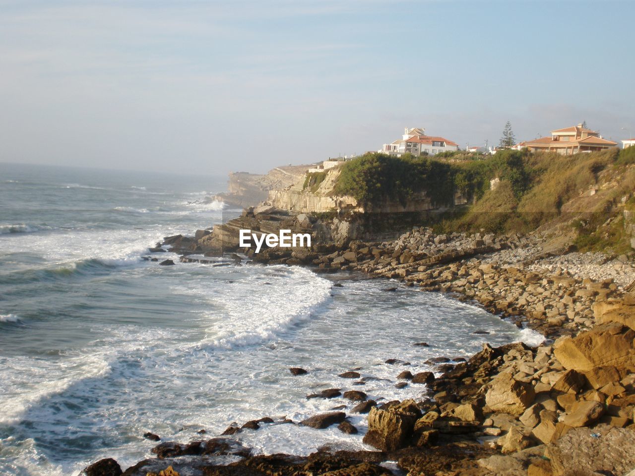 High angle view of cliff by sea against sky