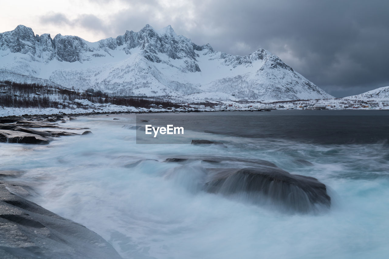 SCENIC VIEW OF SEA AGAINST SNOWCAPPED MOUNTAINS