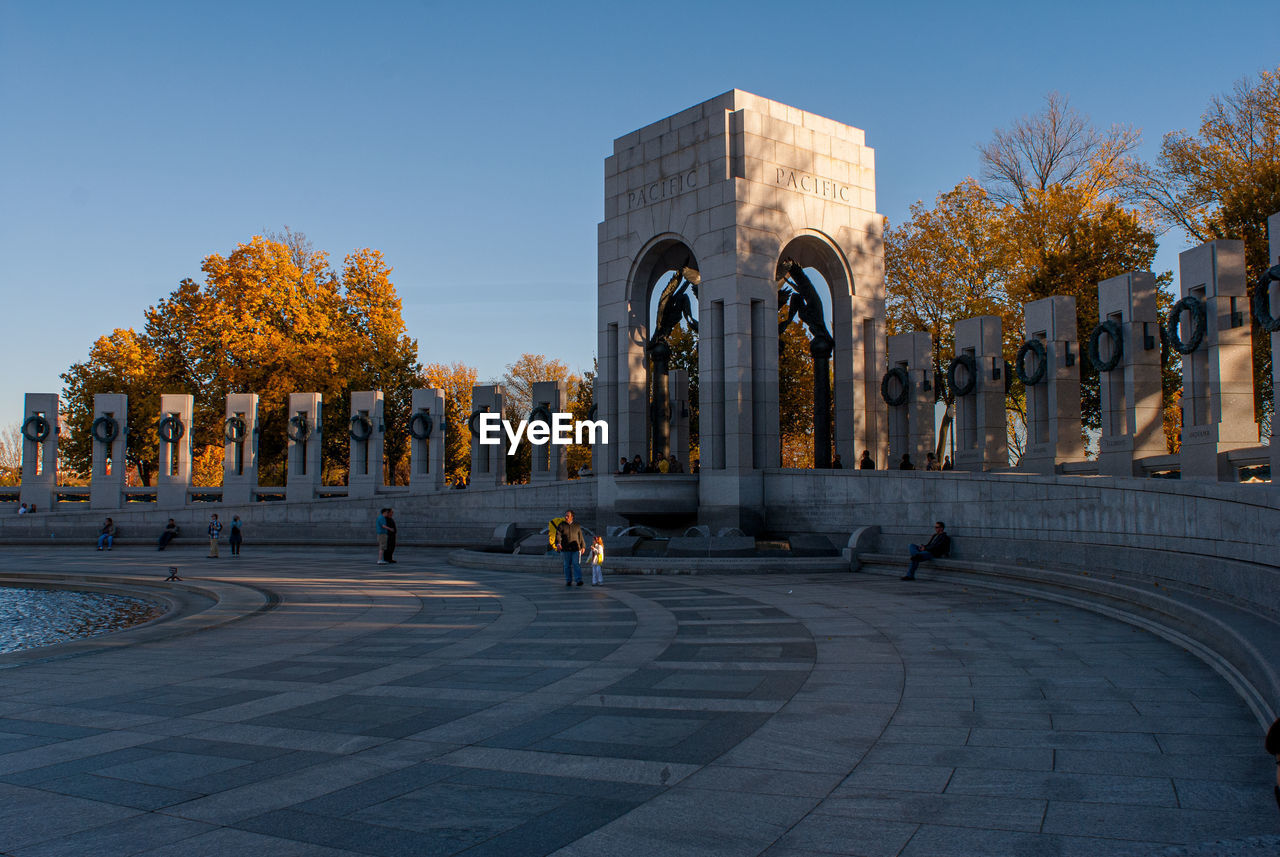 Trees in city against clear sky