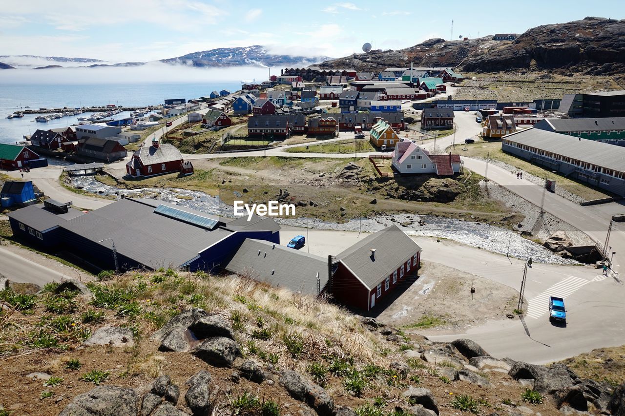 High angle view of buildings by sea against sky