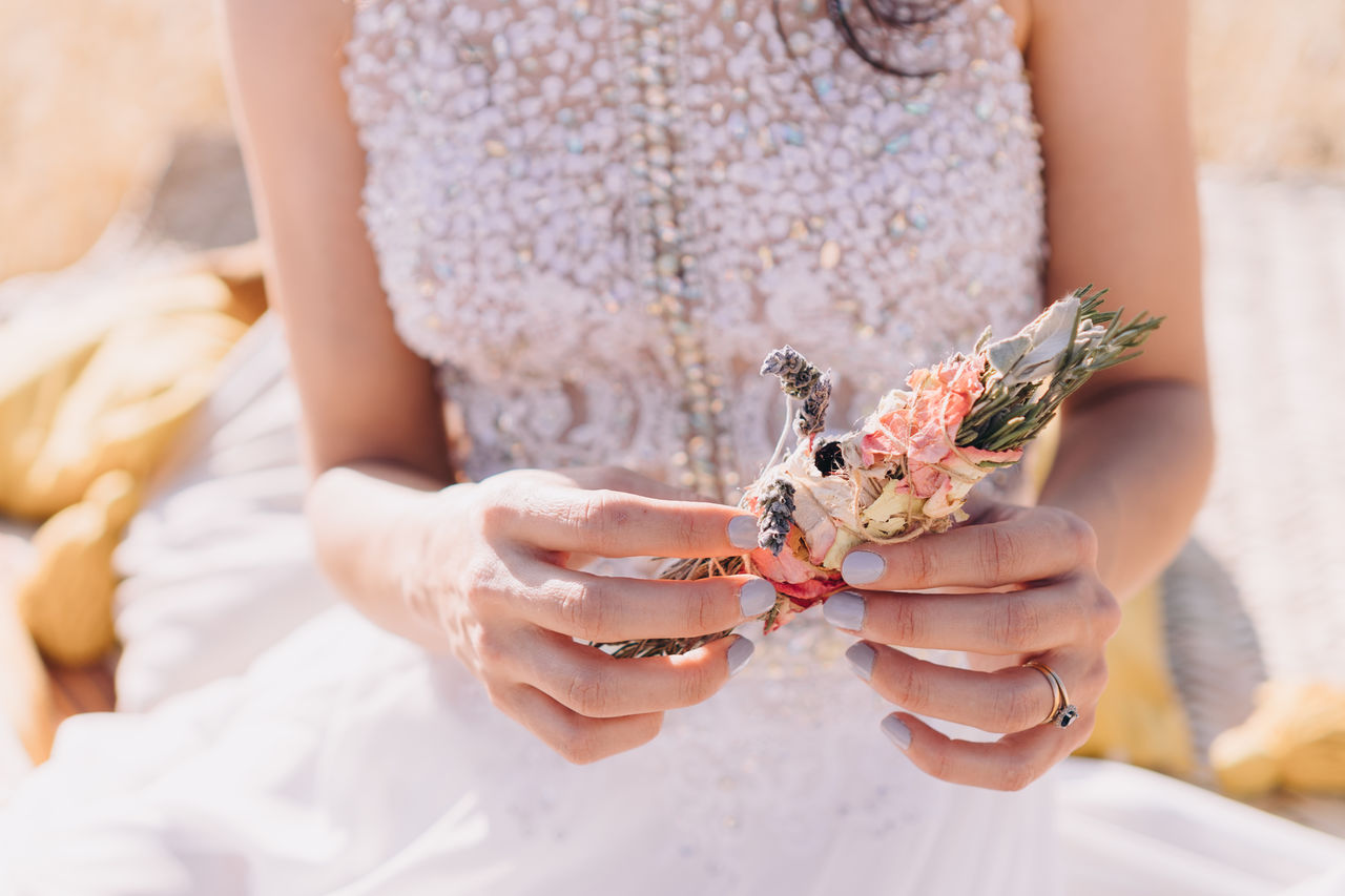 Midsection of woman holding smudge stick