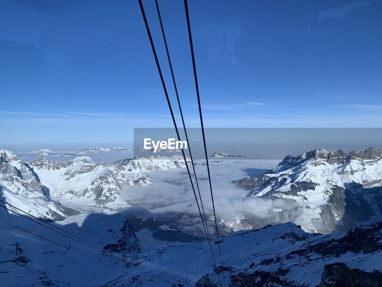 snow, winter, cold temperature, mountain, scenics - nature, mountain range, beauty in nature, landscape, environment, sky, snowcapped mountain, nature, piste, blue, tranquil scene, tranquility, no people, cable, ski mountaineering, ski, ski touring, ski equipment, winter sports, travel, cloud, frozen, day, idyllic, outdoors, travel destinations, non-urban scene, white, mountain peak, cable car, extreme terrain, ski lift, land, summit