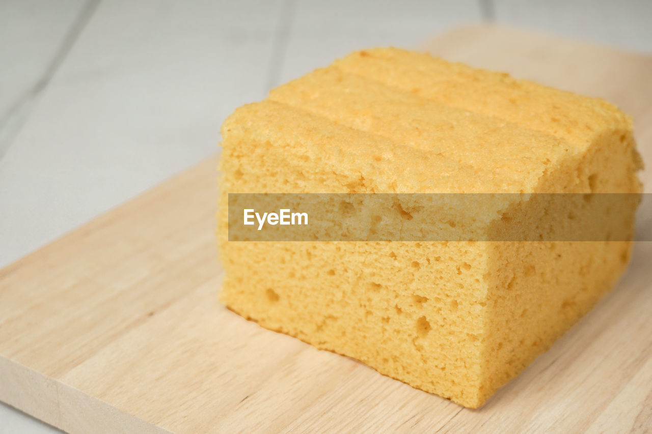 CLOSE-UP OF BREAD ON CUTTING BOARD ON TABLE