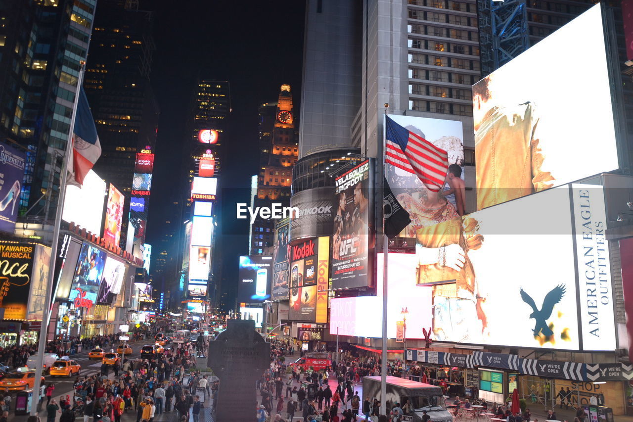 High angle view of people on street amidst buildings at night