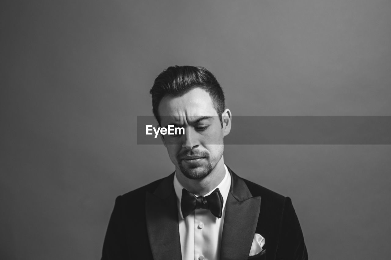 PORTRAIT OF YOUNG MAN AGAINST WHITE BACKGROUND