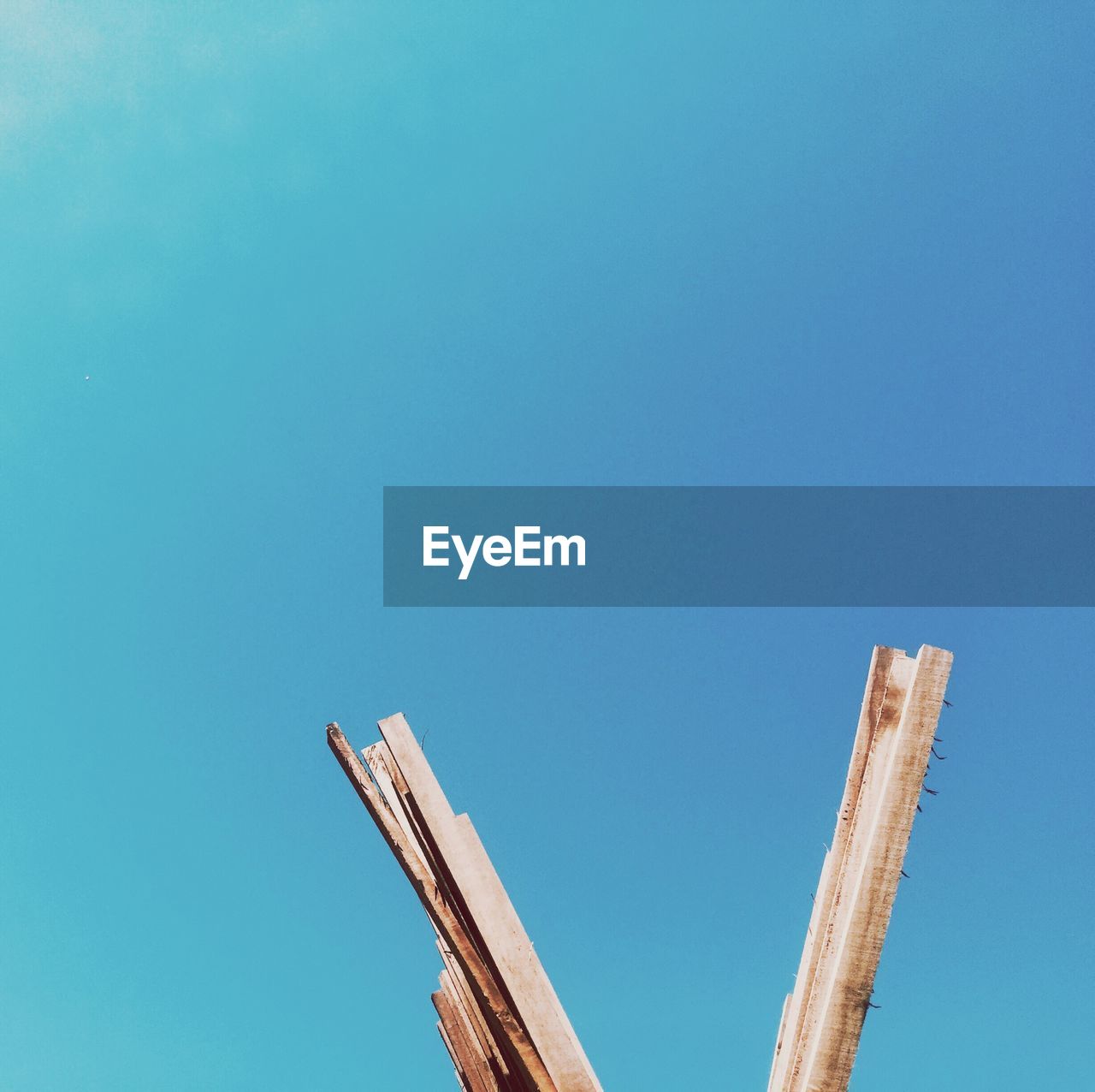 LOW ANGLE VIEW OF WINDMILL AGAINST BLUE SKY