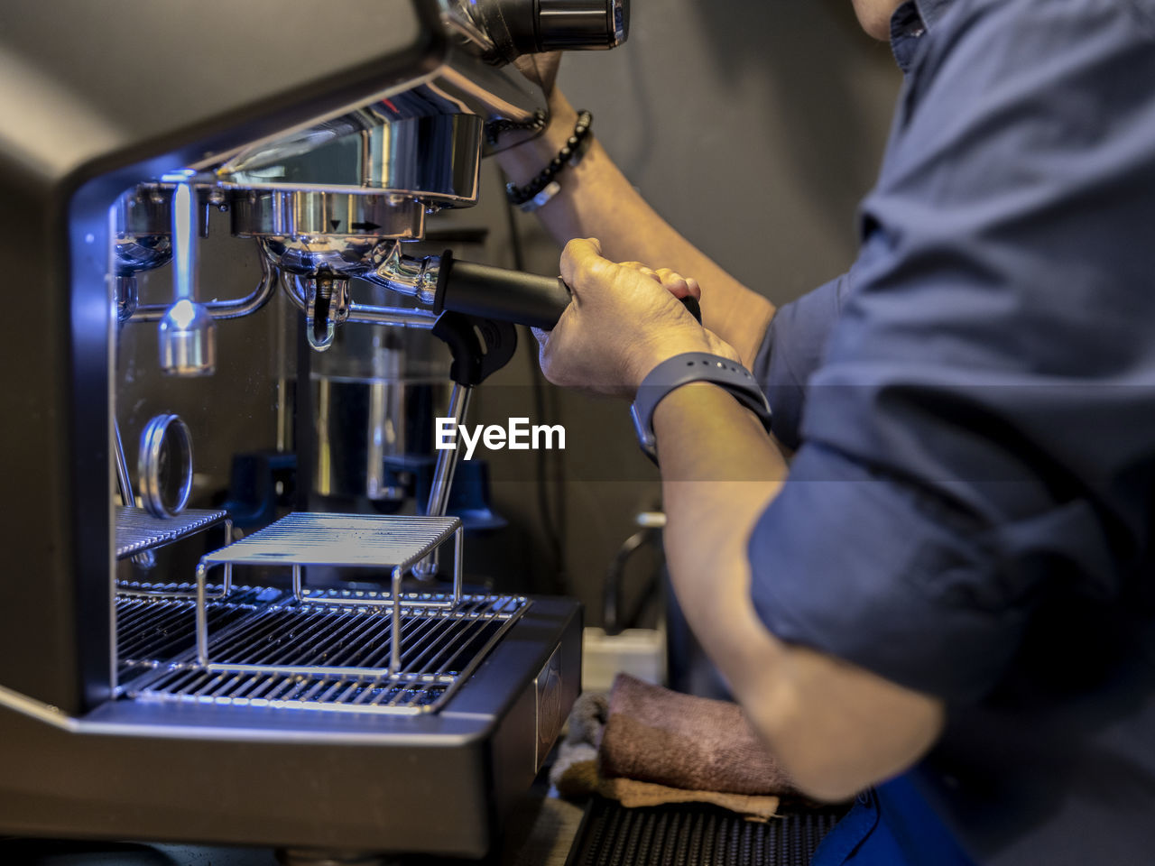 Cropped hands of barista preparing coffee in cafe