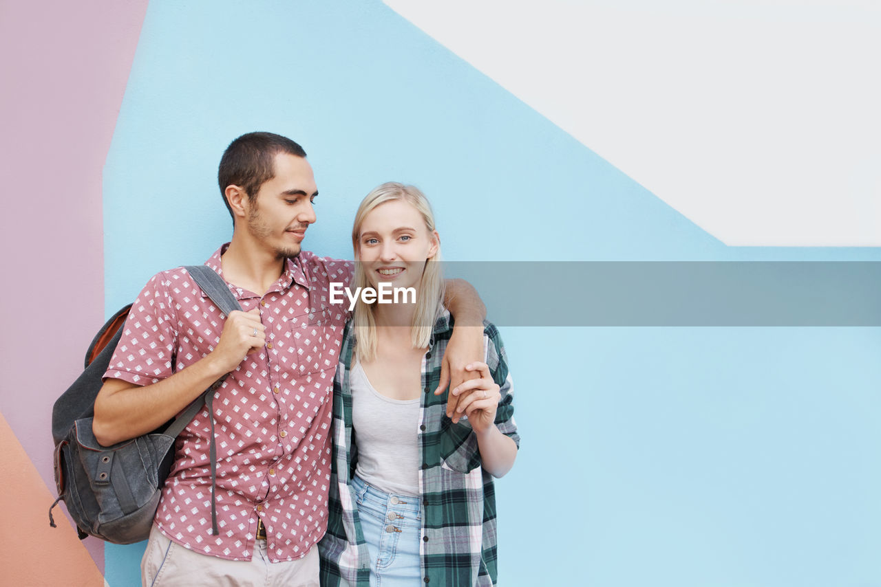 Smiling couple against wall