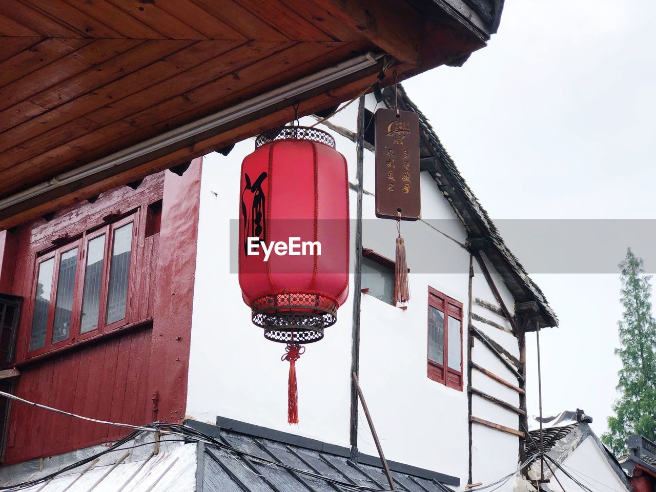 LOW ANGLE VIEW OF RED LANTERNS HANGING ON ROOF OF BUILDING