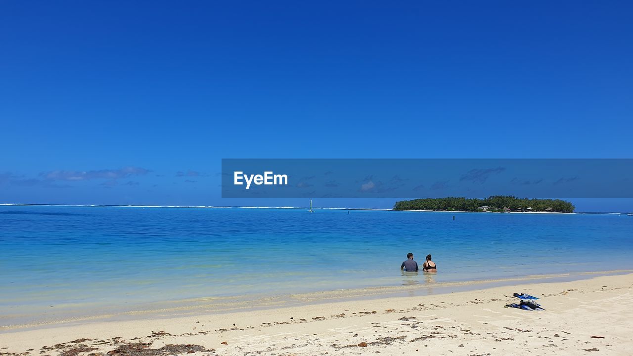 Scenic view of beach against blue sky