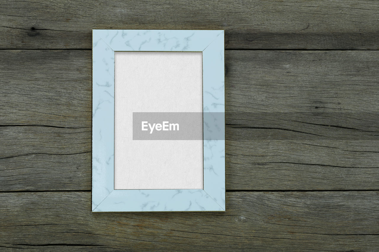 Empty vintage photo frame on old wood background and have copy space for design in your work.