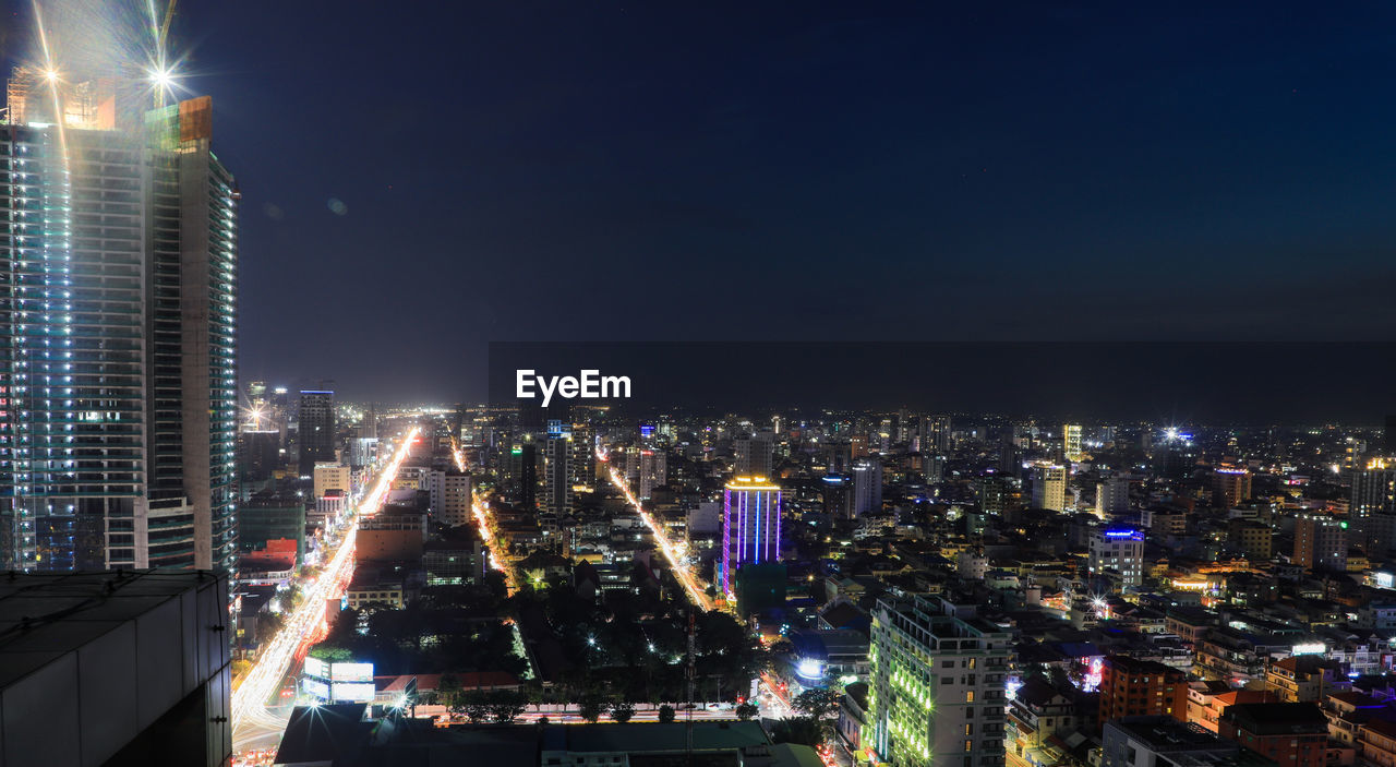 Illuminated buildings in city against sky at night