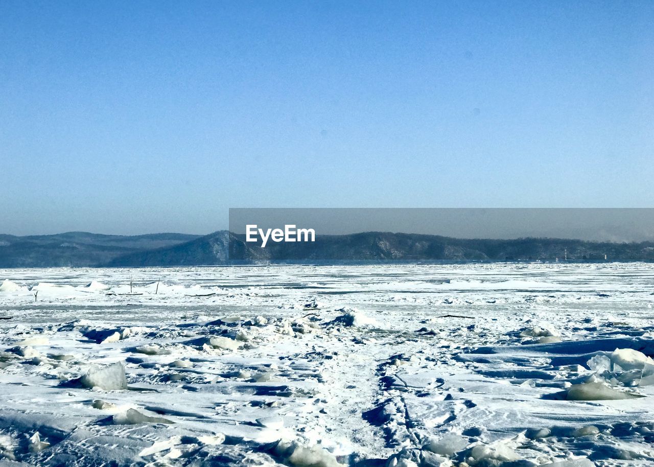 Scenic view of frozen lake against clear sky