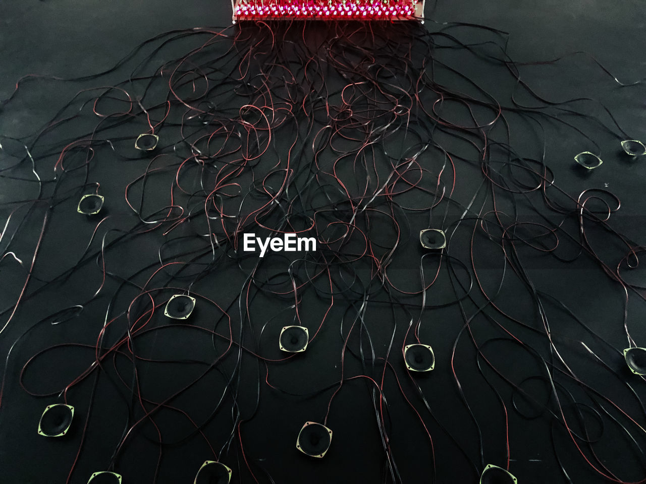 High angle view of speakers amidst tangled cables on floor