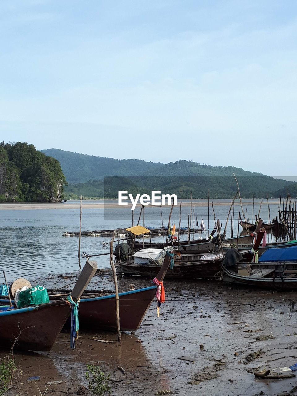 BOATS MOORED ON SHORE AGAINST SKY