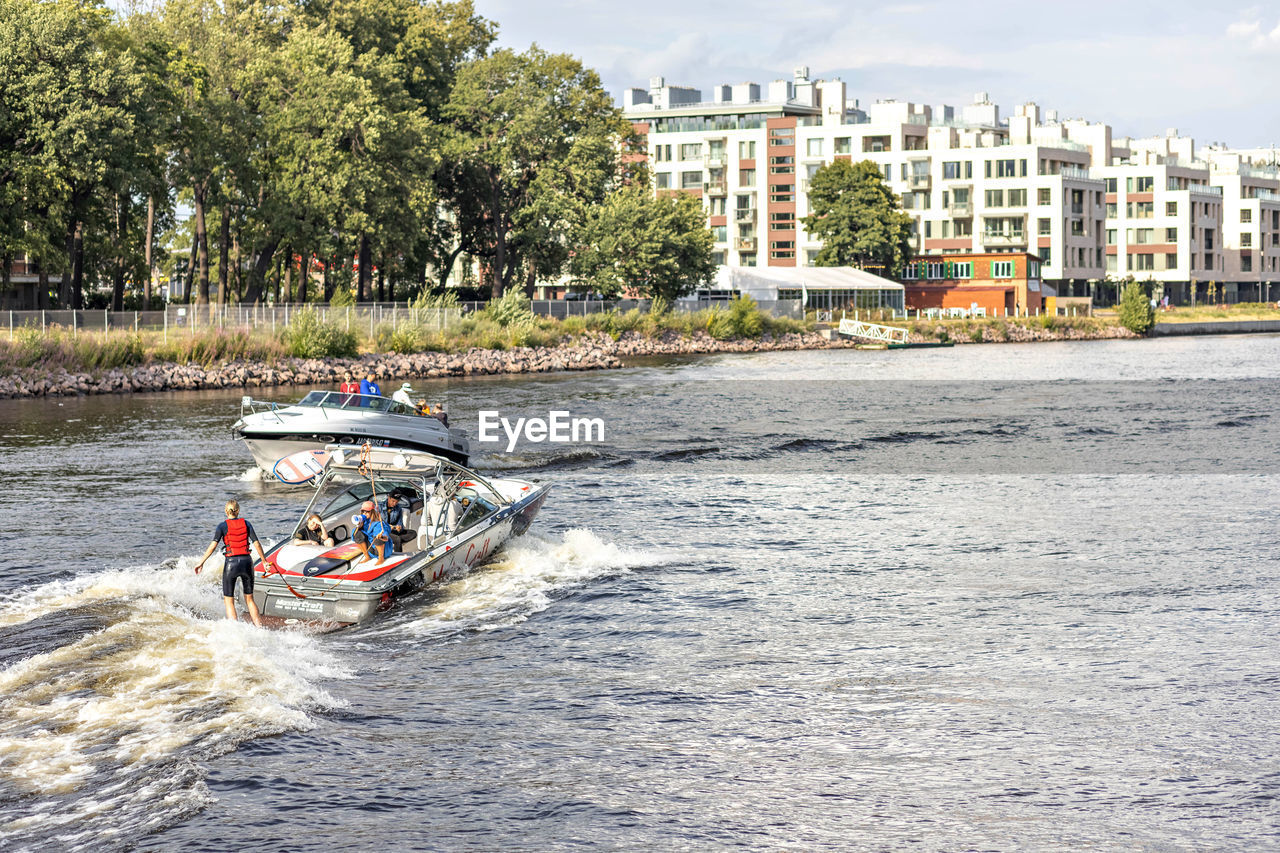 PEOPLE RIDING BICYCLES ON RIVERBANK