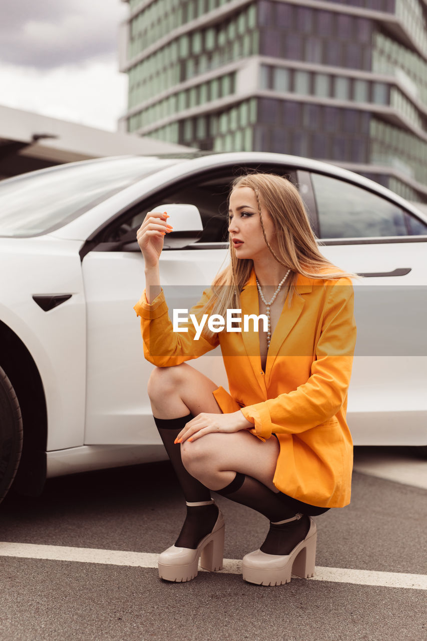 Young woman using mobile phone while sitting in car