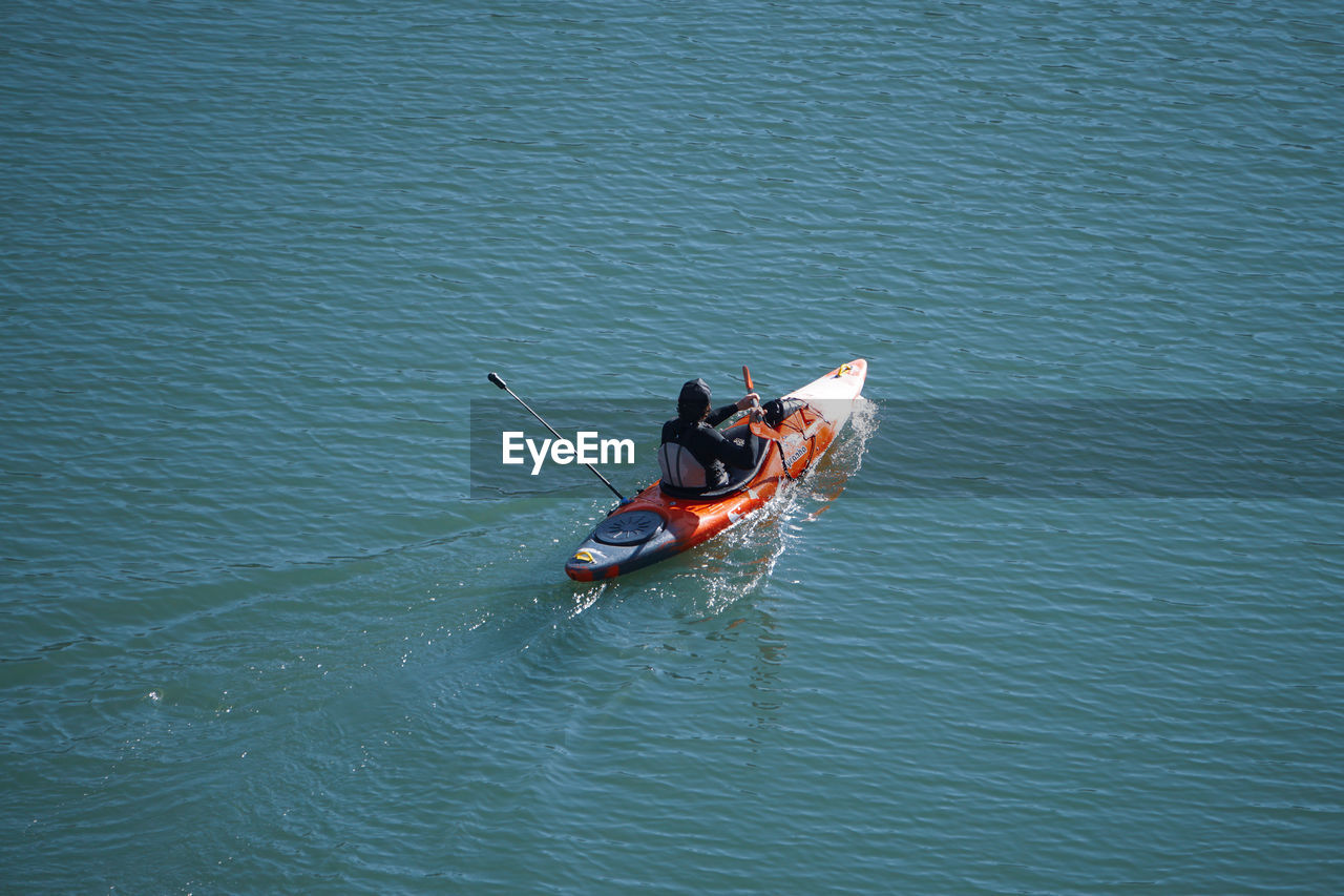 water, nautical vessel, transportation, mode of transportation, high angle view, vehicle, nature, boat, day, waterfront, men, lake, lifestyles, boating, outdoors, one person, leisure activity, travel, oar, rowing, beauty in nature, watercraft, rippled, adult, paddle, motion