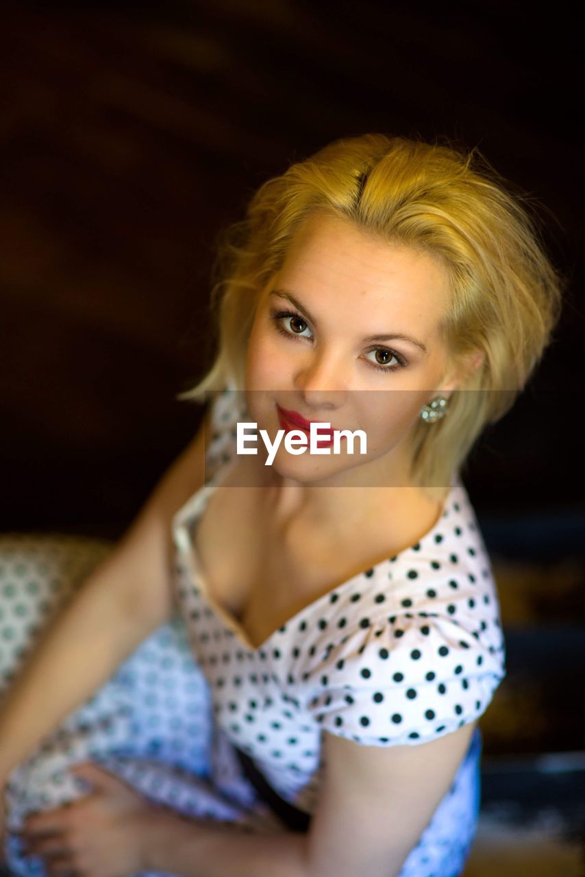 High angle portrait of smiling young woman sitting indoors