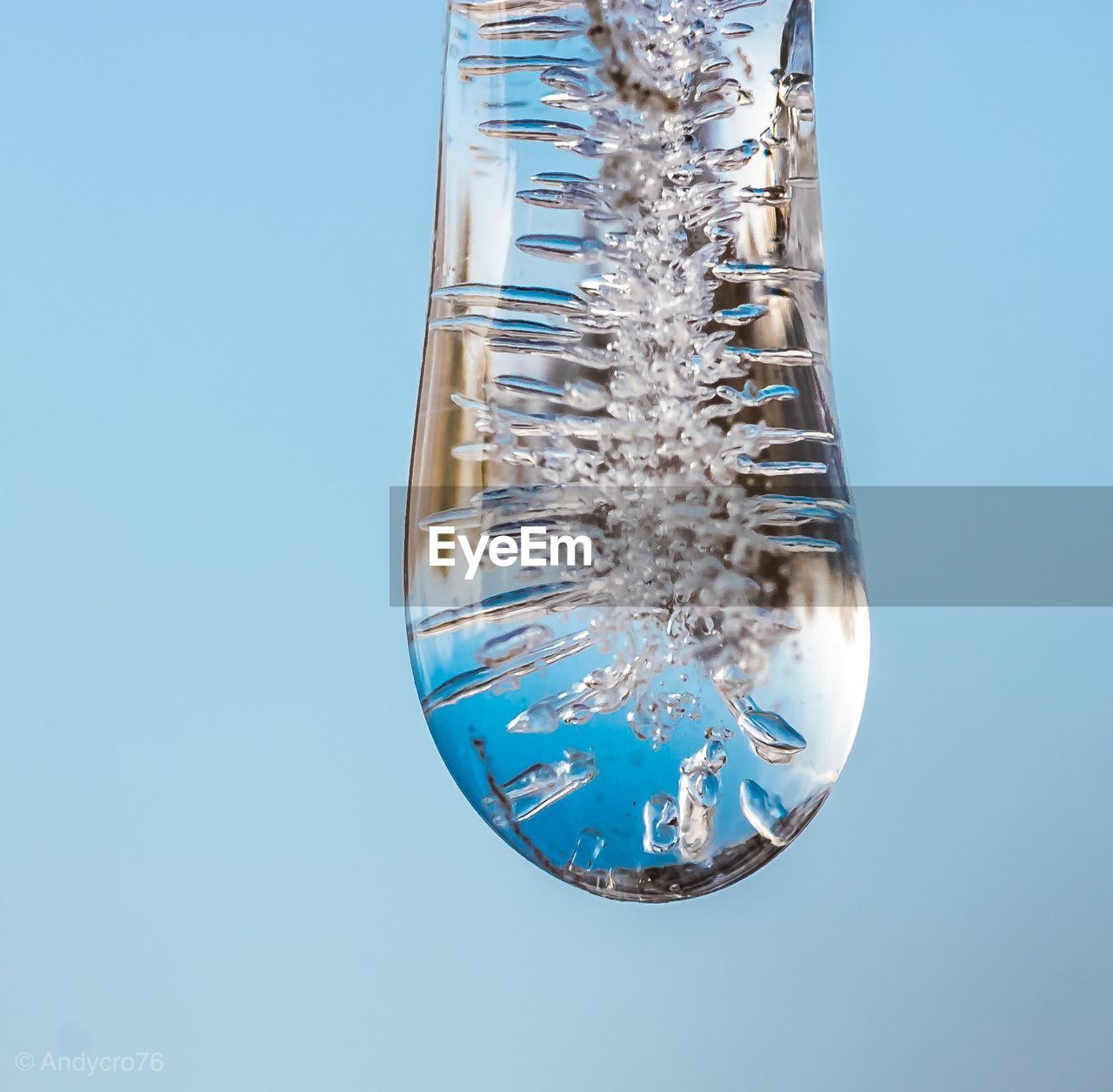 CLOSE-UP OF SNOW COVERED GLASS AGAINST BLUE BACKGROUND