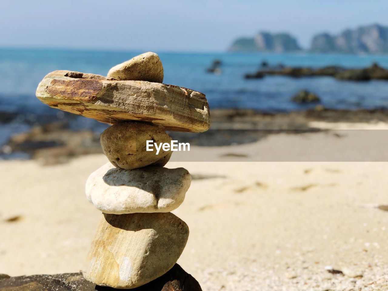 Stack of stones at beach during sunny day