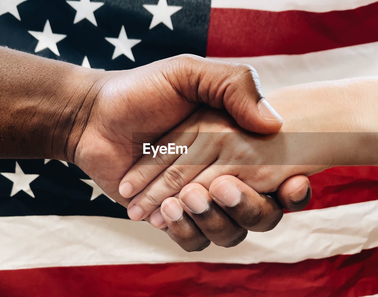 African american man and caucasian woman holding hands or shaking hands togetherness