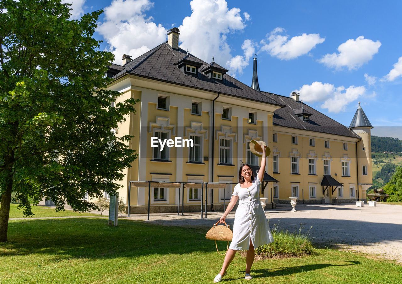 WOMAN WITH BUILDING AGAINST SKY