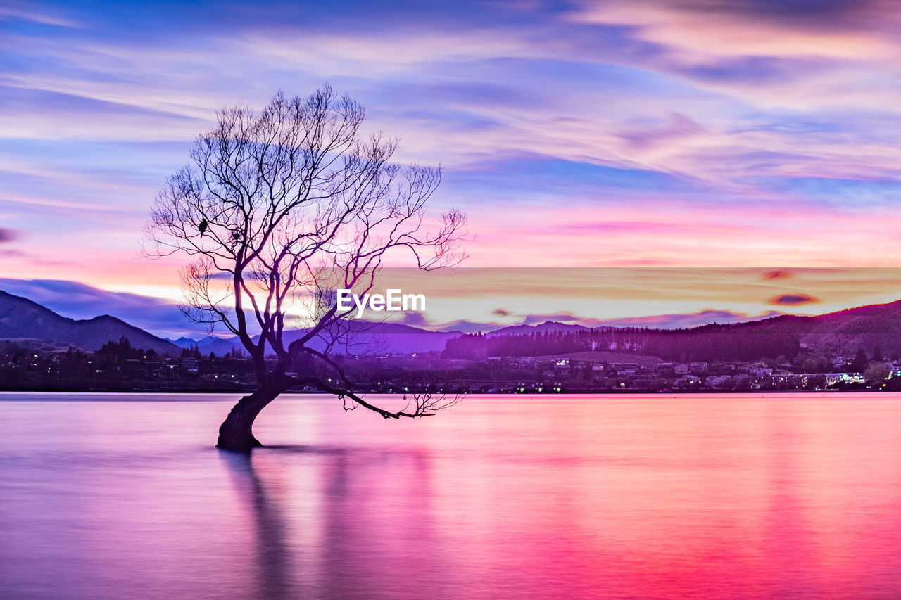 SCENIC VIEW OF LAKE AGAINST SKY AT SUNSET